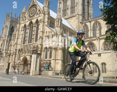A cyclist uses the cycle path next to York Minster in York city centre, one of the areas designated to promote cycling. Stock Photo