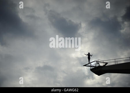 Ballance under heaven. Silhouette of a woman on a high crane. Stock Photo