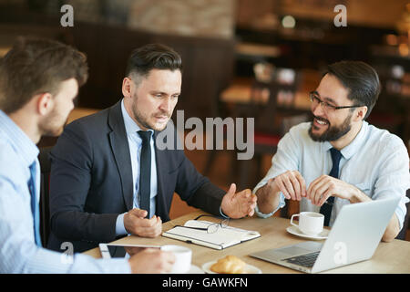 Presenting new important data to colleagues at coffee break Stock Photo