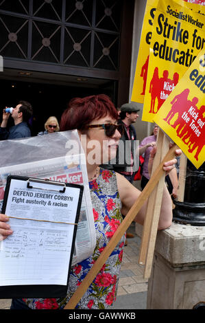 London, UK. 05th July, 2016. A woman with a Defend Jeremy Corbyn petition and Socialist Worker party placards in support of striking teachers at a demonstration on Oxford Circus, London, on Wednesday, July 5th, 2016 Credit:  Jonathan Katzenellenbogen/Alamy Live News Stock Photo