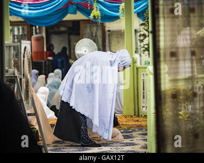 Bangkok, Bangkok, Thailand. 6th July, 2016. A woman lays out her prayer rug before Eid services at Ton Son Mosque in the Thonburi section of Bangkok. Eid al-Fitr is also called Feast of Breaking the Fast, the Sugar Feast, Bayram (Bajram), the Sweet Festival or Hari Raya Puasa and the Lesser Eid. It is an important Muslim religious holiday that marks the end of Ramadan, the Isic holy month of fasting. Muslims are not allowed to fast on Eid. Credit:  ZUMA Press, Inc./Alamy Live News Stock Photo