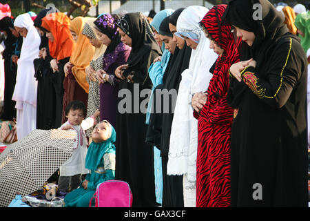 Philippines. 6th July, 2016. A young girl looks on while Muslim adults pray at the Quirino Grandstand. Filipino Muslims from nearby cities converged at the Quirino Grandstand in Manila to celebrate the end of Ramadan. Eid al-Fitr marks the end of the holy month of fasting in Islam. © J Gerard Seguia/ZUMA Wire/Alamy Live News Stock Photo