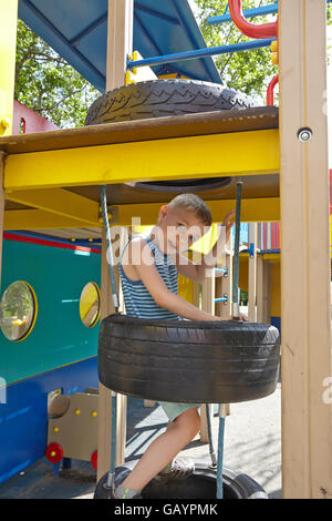 Cute boy playing in tunnel on playground Stock Photo