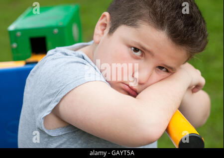 tired sad fat boy sitting on a fitness equipment Stock Photo