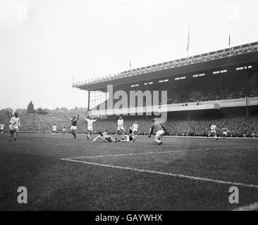 Manchester United goalkeeper Harry Gregg comes out to save from Aresenal centre forward Joe Baker. In the centre is Noel Cantwell, United's left back. Stock Photo