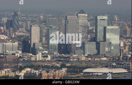 Aerial photo shows a view looking west towards central London, including 30 St Mary Axe, (left), also known as the Gherkin, or the Swiss Re Tower, and Canary Wharf (right). Stock Photo