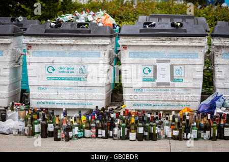 Overflowing recycling glass bottle bank in Winchester, UK with rows of wine bottles lined up in front Stock Photo