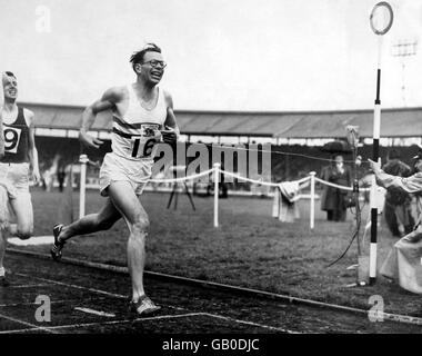 Great Britain's Chris Brasher breaks the tape to win the men's mile Stock Photo