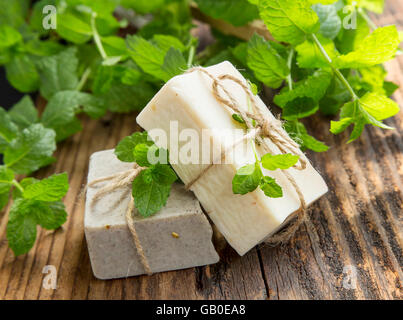 Natural organic mint soaps with mint leaves on wooden background Stock Photo