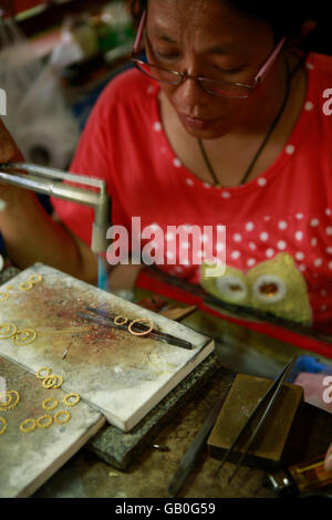 Traditional Thai jewelry being made in the Somsak gold factory near Sukhothai Stock Photo