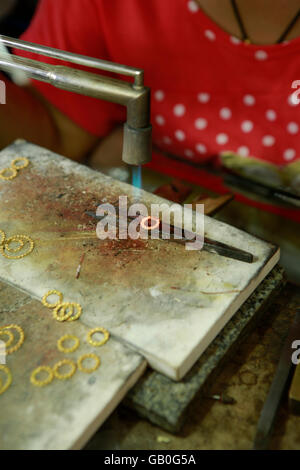 Traditional Thai jewelry being made in the Somsak gold factory near Sukhothai Stock Photo