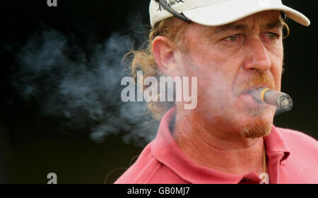 Miguel Angel Jimenez smokes a cigar as he practices on the driving range at the Royal Birkdale Golf Club, Southport. Stock Photo