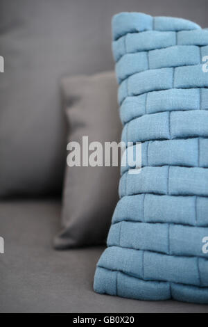 Close up of a light blue cushion on a grey sofa Stock Photo