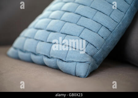 Close up of a light blue cushion on a grey sofa Stock Photo