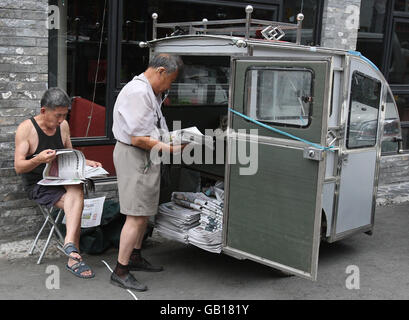 Olympics - Beijing Olympic Games 2008. Men read papers on a newspaper stand near Hou Hai lake in Old Beijing, China. Stock Photo