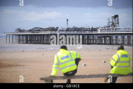 Guards behind the security fence that now surrounds the fire damaged Grand Pier at Weston-super-Mare, after a major fire broke out yesterday. Stock Photo