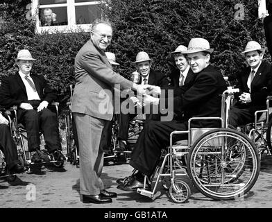 The captain of the Irish team, Father L Close (r), presents a silver trophy, to be competed for by female archers at future games, to Doctor Ludwig Guttman (l), Director of Stoke Mandeville Spinal Injury Unit Stock Photo