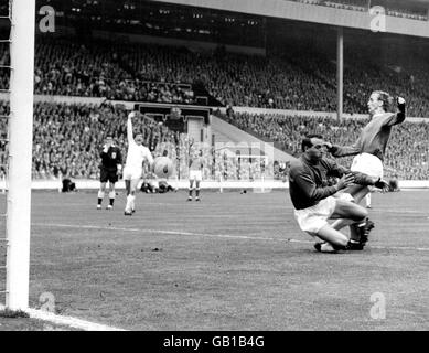 Everton's Alex Young (r) beats Sheffield Wednesday goalkeeper Ron Springett (second r) to the ball, but referee Jack Taylor (l) has his whistle in his mouth to signal an infringement Stock Photo