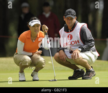 South Korea's Bo Bae Song (left) looks at her putt on the 15th with her caddy during Round Two of the Ricoh Women's British Open at Sunningdale Golf Club, Berkshire. Stock Photo