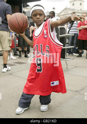 Shekeem O'Connor (aged 7 from Camberwell and a member of Brixton Basketball Club), wearing a signed shirt given to him by Chicago Bulls and Great Britain national team basketball player Luol Deng, during the NBA Jam Van event (the NBA's free interactive basketball touring programme) in Trafalgar Square, central London. Stock Photo