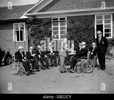 The captain of the Irish team, Father L Close (third r), presents a silver trophy, to be competed for by female archers at future games, to Doctor Ludwig Guttman (c), Director of Stoke Mandeville Spinal Injury Unit Stock Photo