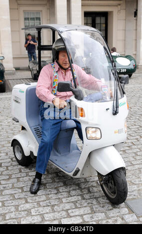 Sir Stirling Moss who leaves the Lanesborough Hotel in London on his three-wheeled Canopy scooter after celebrating the 60th anniversary of Jaguar's XK range. Stock Photo