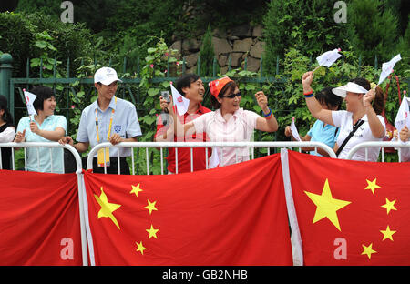 A spectator encourages people to cheer the cyclists on during the 2008 Beijing Olympic Games in Beijing, China. Stock Photo