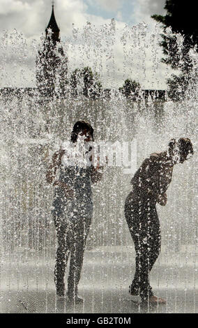 Girls play in the fountains outside the Hayward Gallery, on London's South Bank, as Londoners enjoy the sunny weather. Stock Photo