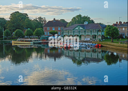 Early morning river scene on the River Avon in Stratford upon Avon with a variety of boats moored outside the old boathouse. Stock Photo