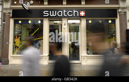 General view of shoppers walking past a Swatch store on Oxford Street in London. Stock Photo