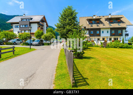 Street in small alpine village on shore of Weissensee lake with traditional houses in background, Austria Stock Photo