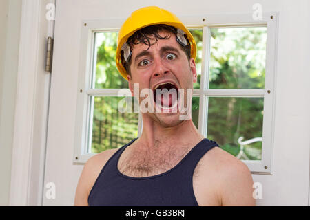 Young handsome construction worker in tank top and yellow hat Stock Photo