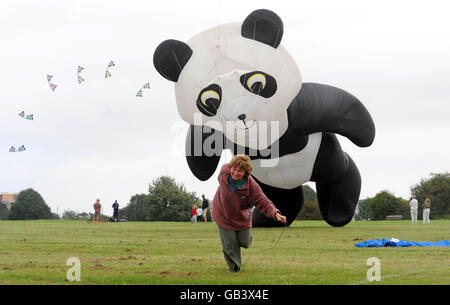 Kathleen Beattie, 44, from Wokingham struggles to launch her panda into the air during the run up to this weekend's Bristol International Festival of Kites & Air Creations in Bristol. The event takes place in Ashton Court, Bristol, on August 30 and August 31. Stock Photo