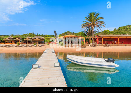 Wooden jetty and boat on Santa Manza beach, Corsica island, France Stock Photo