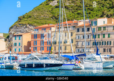 BONIFACIO PORT, CORSICA ISLAND - JUN 24, 2015: boats anchoring in Bonifacio port with colorful houses in background. Bonifacio i Stock Photo