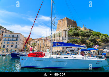 BONIFACIO PORT, CORSICA ISLAND - JUN 25, 2015: sail boat entering Bonifacio port with citadel building in background. Bonifacio Stock Photo