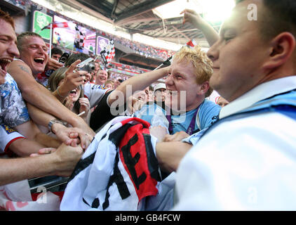 Rugby League - Carnegie Challenge Cup Final - Hull FC v St Helens - Wembley Stadium. St Helens' James Graham is mobbed by fans as he celebrates wining the Carnegie Challenge Cup Final at Wembley Stadium, London. Stock Photo