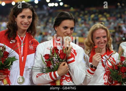 Russia's gold medal winner Yelena Isinbayeva (centre) kisses her medal as she is flanked by Russia's bronze medal winner Svetlana Feofanova (right) and USA's silver medal winner Jennifer Stuczynski during the medal ceremony for the women's pole vault during the athletics competitions in the National Stadium at the 2008 Olympics in Beijing, China. Stock Photo