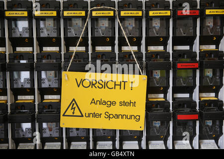 Warning Sign, Caution System is under voltage electrical switchboard, Germany Stock Photo