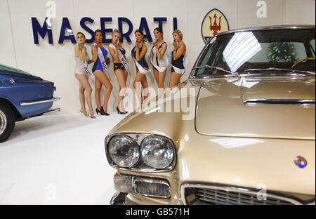 Models stand beside a Maserati on the first day of the Goodwod Revival Meeting near Chichester, West Sussex. The event relives the glory days of Goodwood Motor Circuit, which ranked alongside Silverstone as one of Britain's leading racing venues throughout its active years between 1948 and 1966. Stock Photo