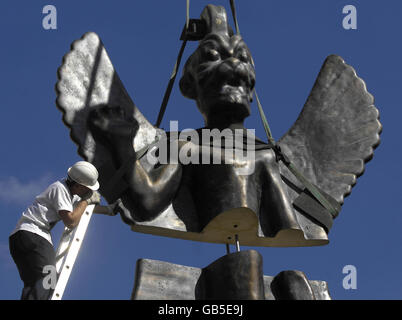 Workmen help to assemble a 6-meter statue of the Assyro-Babylonian god Pazuzu on the rooftop of the ICA in London. Stock Photo