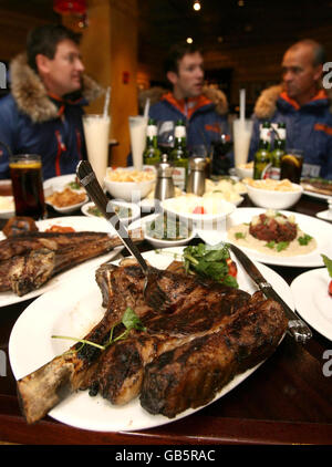 Arctic explorers Will Gow (left), Henry Adams (centre) and Henry Worsley (right) eat a 6000 calorie meal at the Green Door Bar and Grill in London. Stock Photo