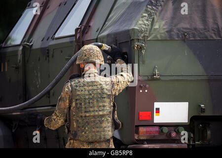 soldier fuels a military armored truck Stock Photo