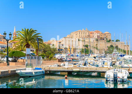 CALVI, CORSICA ISLAND - JUN 28, 2015: view of sailing boats and citadel with houses in Calvi port. This town is has luxurious ma Stock Photo