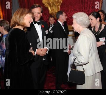 Britain's Queen Elizabeth II chats with newsreader Katie Derham, at St James' Palace in London, at a reception to mark the 60th anniversary of the Leonard Cheshire Disability. Stock Photo