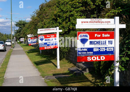 Houses for sale and sold real estate residentialsigns lining a street in Vancouver, British Columbia, Canada Stock Photo