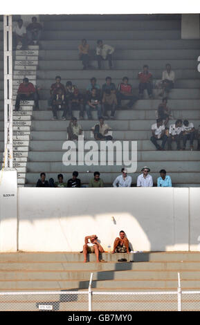 Cricket - Warm Up Match - Mumbai Cricket Association President's XI v England XI - Brabourne Stadium - Mumbai. Two fans sunbathe during the warm up match at the Brabourne Stadium, Mumbai, India. Stock Photo