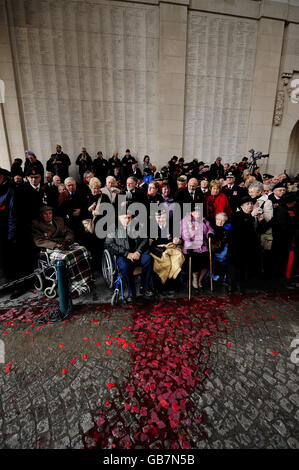 British veterans in front of the names of British and Commonwealth servicemen killed in the Great War with a river of red running towards them. Heavy rain fell as thousands of poppies were dropped on the ceremony and the red dye ran from the poppies to form small blood red rivers after a Remembrance Service at the Menin Gate in Ypres ,Belgium today which marks the 90th Anniversary of the end of the Great War. Stock Photo