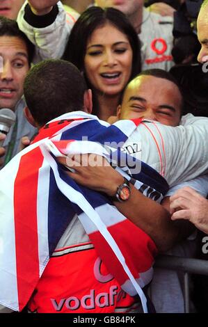 Lewis Hamilton celebrates with his brother Nick and girlfriend Nicole Scherzinger after winning the Formula One Drivers' World Championship