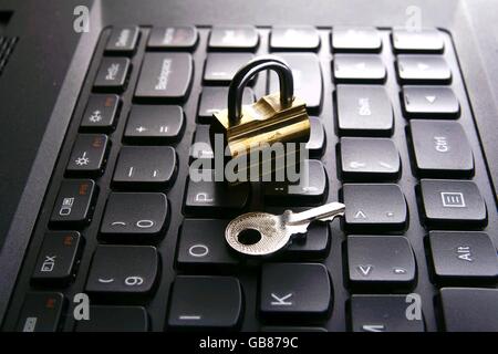 Padlock and key on top of a computer keyboard Stock Photo